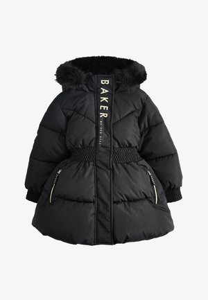 Bambino che indossa un piumino nero con cappuccio foderato in pelliccia, vita elastica e tasche con cerniera, in piedi su uno sfondo chiaro e uniforme.