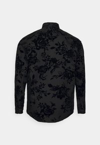 Camicia nera a maniche lunghe con motivo floreale tono su tono, colletto a punta e polsini con bottoni. Il tessuto ha una finitura liscia e strutturata.