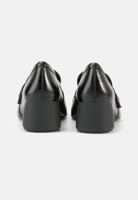 Czarne skórzane szpilki z połyskującym wykończeniem, zaokrąglonym noskiem i niskim, szerokim obcasem. Charakterystyczne detale to nowoczesny design i gładka faktura.