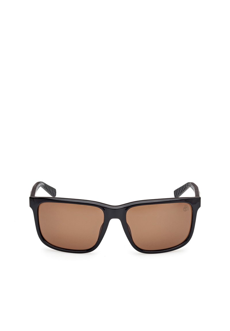 Czarne okulary przeciwsłoneczne z prostokątnymi brązowymi soczewkami, teksturowanymi zausznikami i solidnym, matowym wykończeniem. Posiadają zakrzywione, elastyczne końcówki dla większego komfortu.