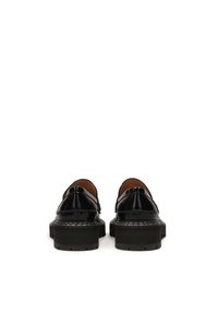 Black patent leather shoes with a chunky rubber sole, detailed stitching, and a scalloped edge along the collar.