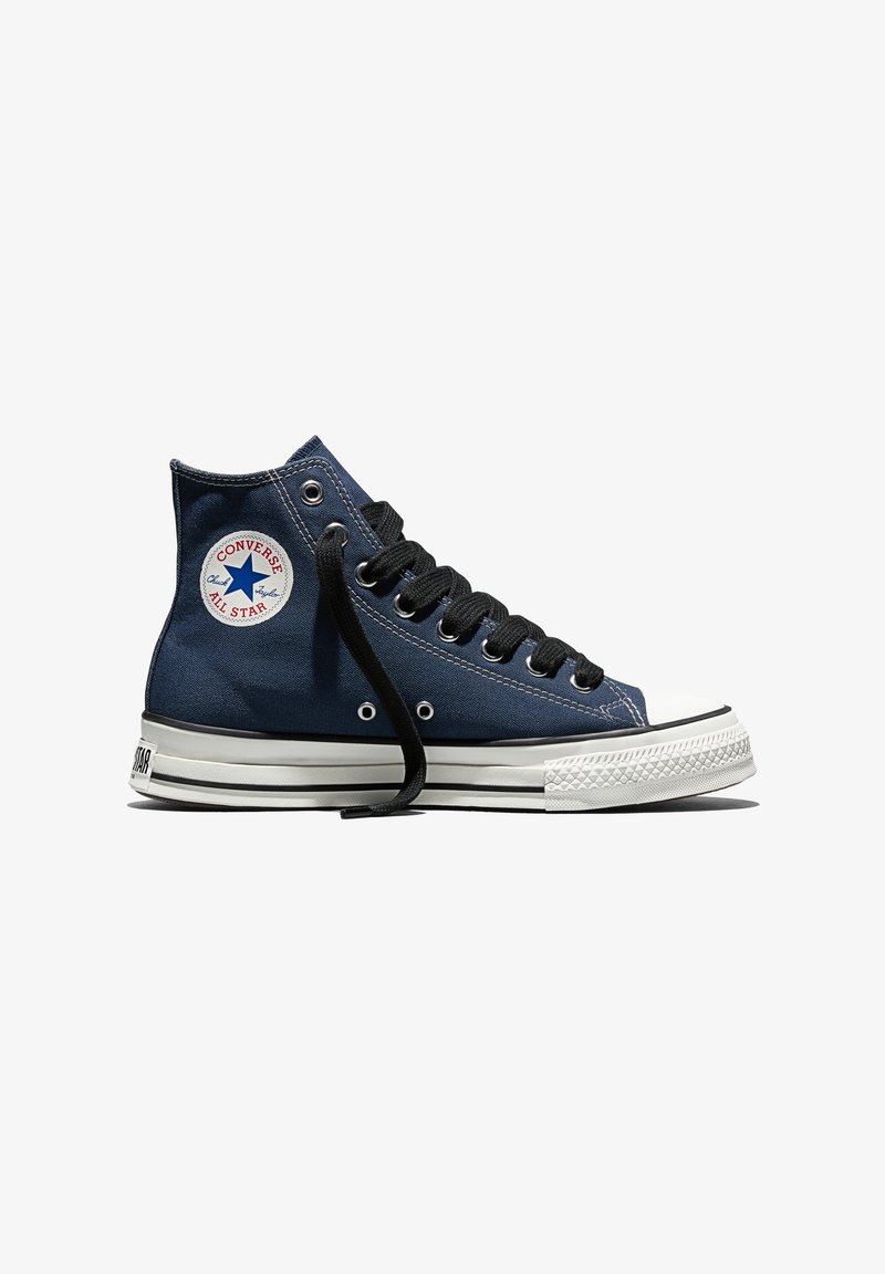 Baskets montantes Converse Chuck Taylor All Star bleu marine avec lacets noirs et semelle en caoutchouc blanche, vues de profil sur fond blanc.