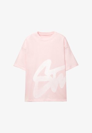 Light pink oversized t-shirt made of cotton, featuring a large white abstract logo design on the front. Short sleeves and a rounded neckline.