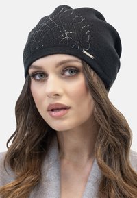 Berretto di maglia nero con abbellimenti scintillanti e un accento metallico. Texture morbida, design scivolato e dettagli intricati sul davanti.