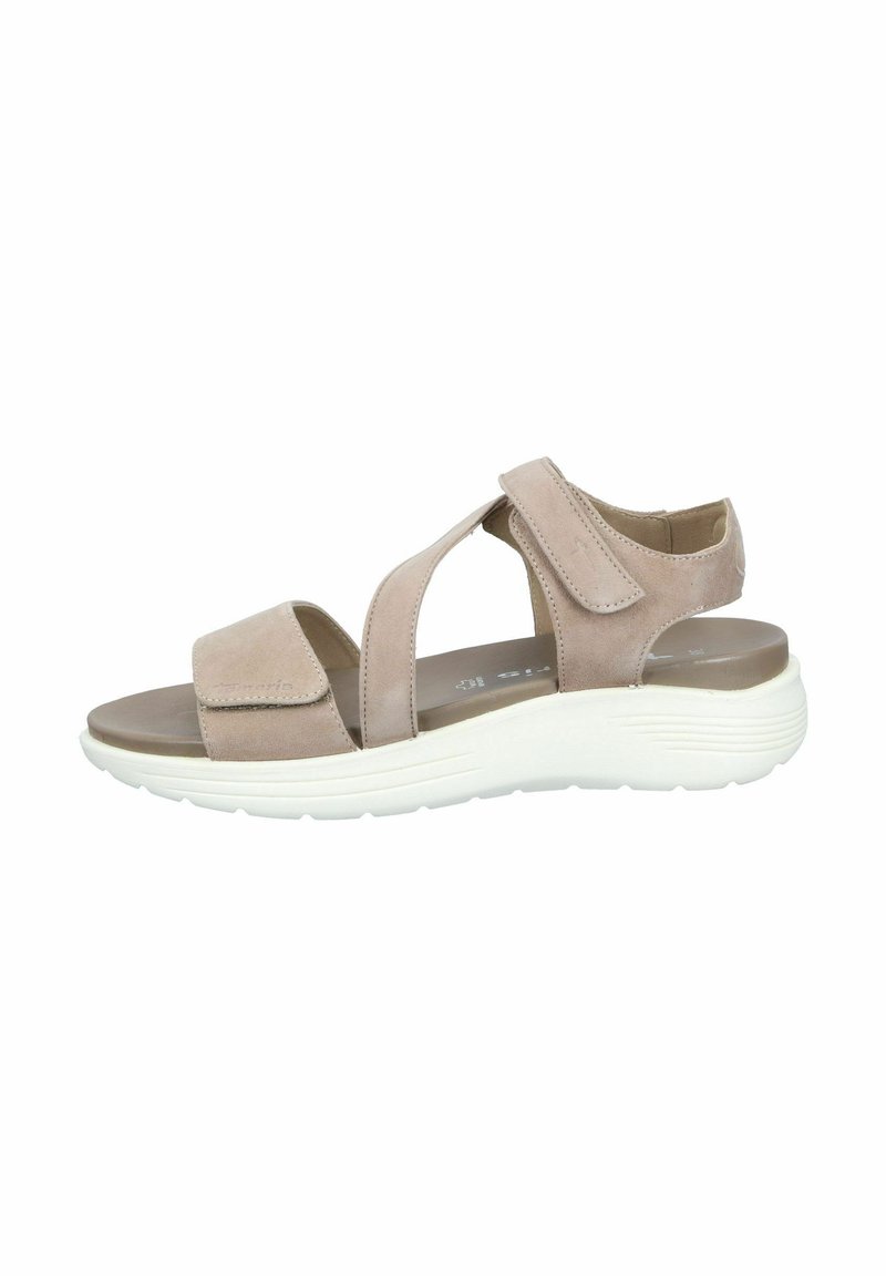 Beige suede sandal with Velcro straps, open sides, and a cushioned insole. Features a white rubber sole with textured patterns.