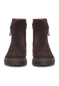 Botines de ante marrón oscuro con cremalleras laterales, suelas planas de goma negra y costuras marrones en contraste. Diseño de caña corta, textura suave.