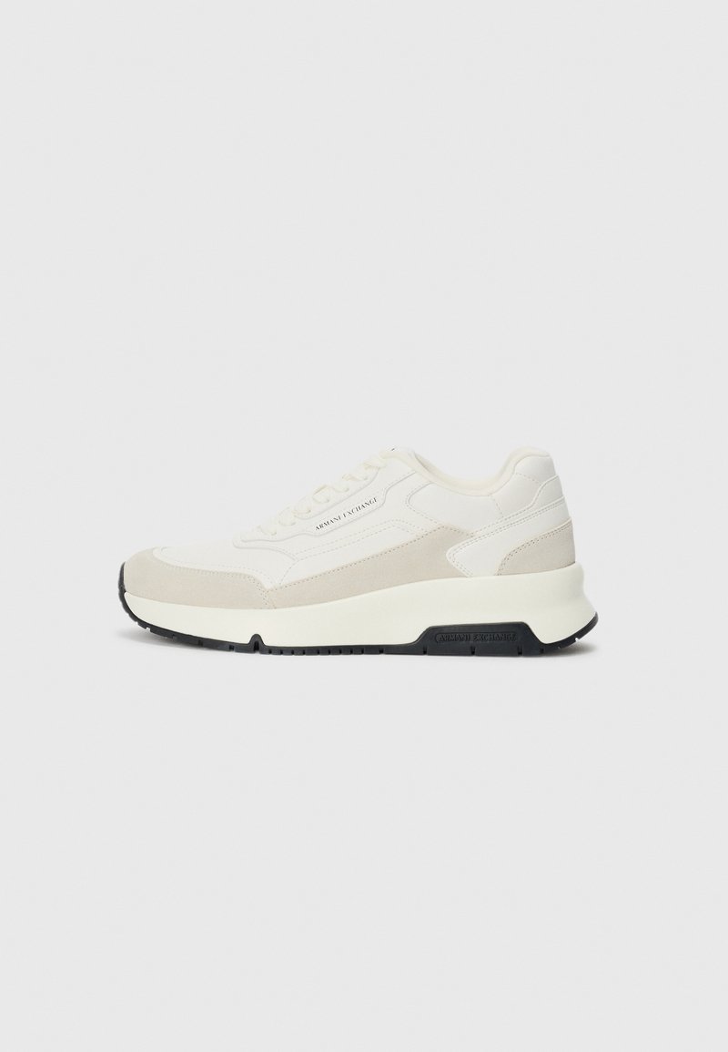 Hvit og beige lavsnøring sneaker med snøring foran, svart såle, og "Armani Exchange" merking på siden og sålen.