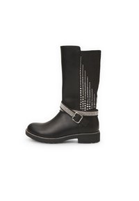 Bota negra de cuero sintético hasta la rodilla. Presenta adornos de tachuelas plateadas en el costado y un cinturón decorativo plateado con hebilla.
