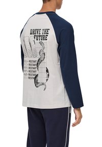 Langarm-T-Shirt mit weißem Körper und marineblauen Raglanärmeln. Grafikdruck auf der Rückseite zeigt Telefone, eine Schlange und den Text "Fahre die Zukunft."
