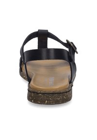Zwarte leren sandalen met een platte zool, verstelbare band en een bruin, gestructureerd voetbed. Lichtgewicht ontwerp met accenten van natuurlijke vezels.