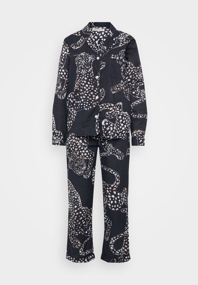 Fekete pizsama szett leopárd mintával, világos krém színű kiegészítőkkel. Tartalmaz egy gombos inget és hozzáillő nadrágot.