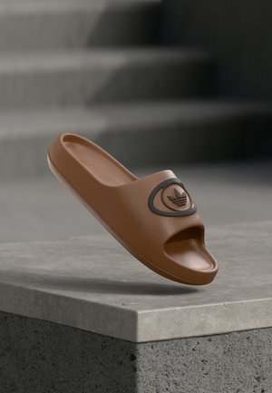 Sandali ciabatta marroni in plastica testurizzata, con design a punta aperta e dettaglio logo circolare sulla fascia anteriore.