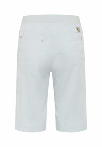 Weiße knielange Shorts mit Gesäßtaschen, Metallnieten und einem breiten elastischen Bund, von hinten gezeigt.