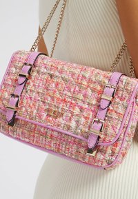 Torebka na ramię z tweedu w odcieniu różowym i wielokolorowym z błyszczącymi różowymi akcentami, szczegóły podwójnego zapięcia oraz łańcuszkowym paskiem. Powierzchnia teksturowa i logo.