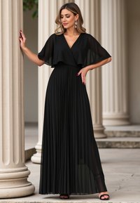 Czarna plisowana sukienka z dekoltem w kształcie litery V i przezroczystymi falbaniastymi rękawami, z dopasowaną talią i zwiewną spódnicą, w połączeniu z czarnymi sandałami.