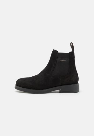 Black suede ankle boot featuring elastic side panels, a pull tab, rounded toe, and a flat rubber sole for stability. GANT logo on the side.