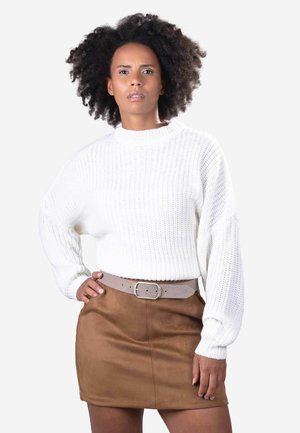 Maglione bianco lavorato a maglia con scollatura tonda e maniche lunghe, abbinato a una mini gonna in suede marrone e una cintura grigia chiara.
