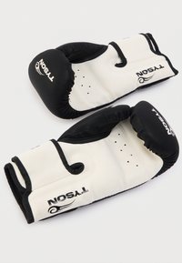 Λευκά και μαύρα γάντια πυγμαχίας από συνθετικό υλικό, με επενδεδυμένες μανσέτες, οπές αερισμού και λογότυπο της μάρκας στην επιφάνεια.