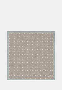 Tovaglietta beige con pois bianchi, bordata da un morbido bordo blu, realizzata in tessuto testurizzato. Nome del marchio "BOGGI" mostrato nell'angolo.