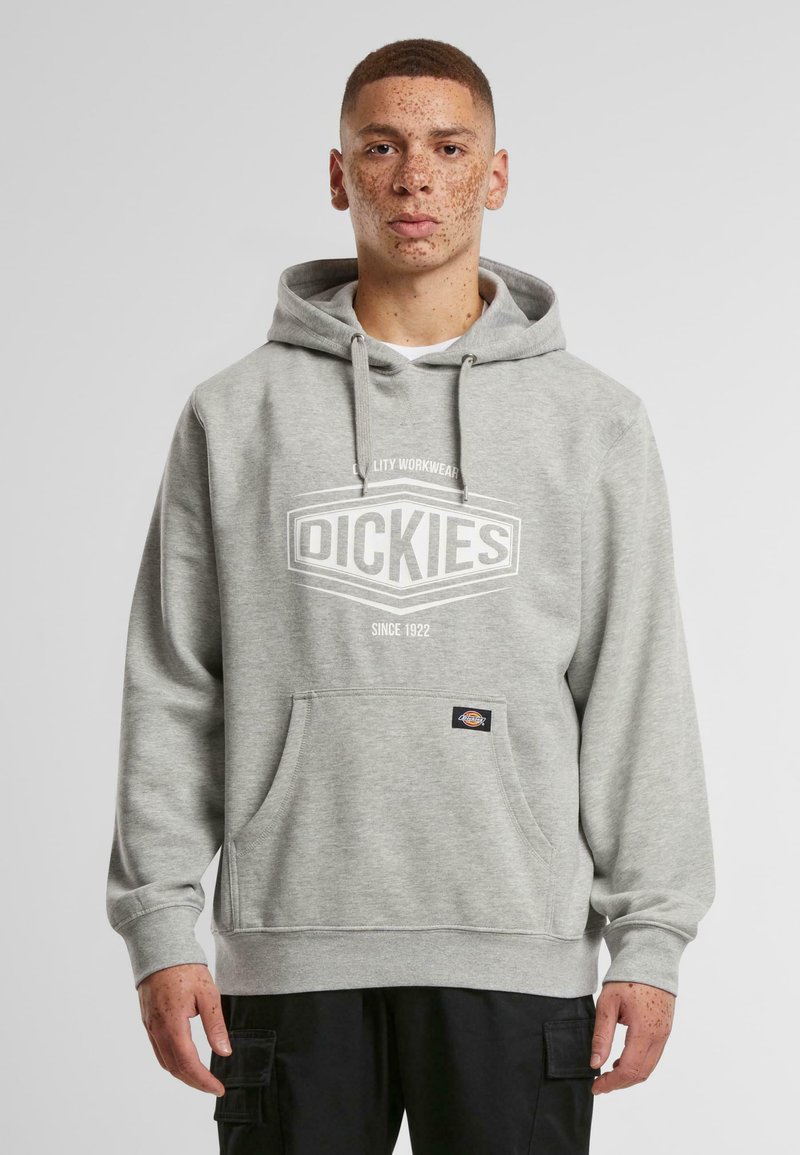 Szürke kapucnis pulóver, elülső zsebbel, fehér logóval, amelyen a "DICKIES" felirat található. Puha anyagból készült, húzózsinórral ellátott kapucnival és bordázott mandzsettával.