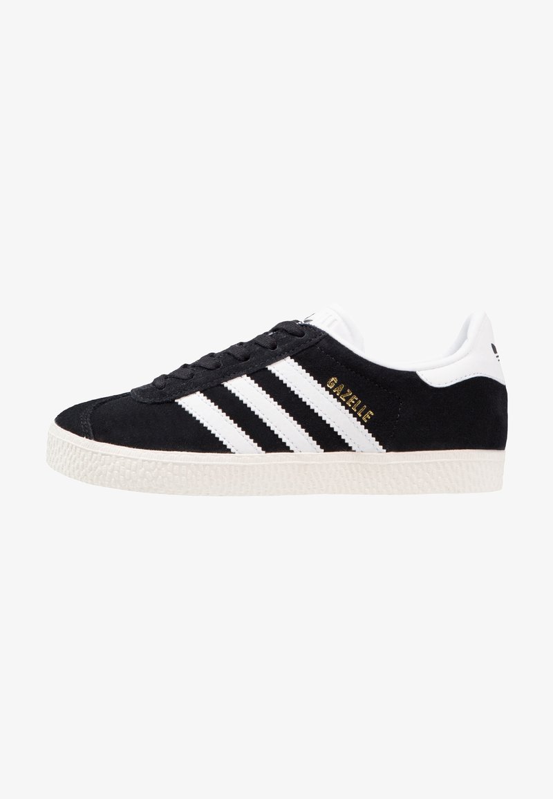 Baskets Adidas Gazelle noires avec des rayures blanches, semelle blanche et texte doré "GAZELLE" sur le côté.
