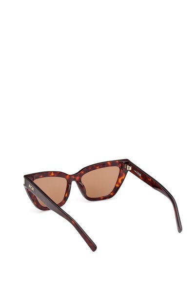 Ochelari de soare cu ramele în model tartă, cu design în formă de ochi de pisică, lentile maro și logo MCM pe brațe. Textură netedă și formă unghiulară pentru un aspect îndrăzneț.