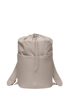 Beiger Rucksack mit Kordelzug, gepolsterten Schultergurten und Fronttasche, mit "GOT BAG"-Logo unten in der Mitte.