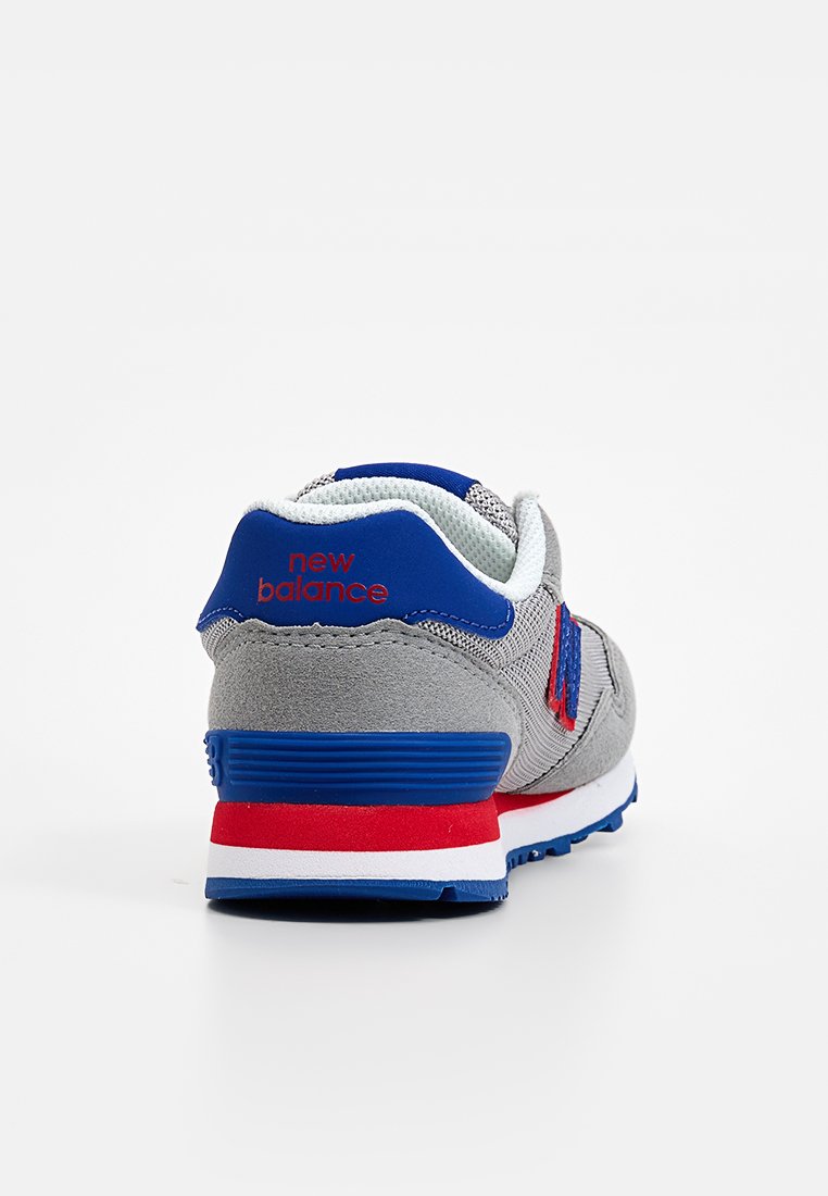 Baskets grises avec des accents bleus et rouges, tige en mesh, col rembourré et semelle intermédiaire blanche avec un design à rayures bleues et rouges.