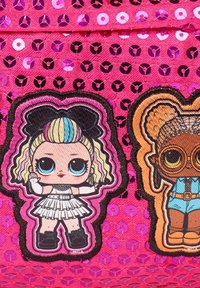 Bolso rosa con textura de lentejuelas. Presenta dos parches bordados: uno con una muñeca en un vestido blanco y otro con una muñeca vestida de azul y con gafas.