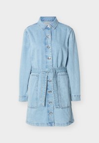 Φόρεμα πουκάμισο από ανοιχτό μπλε τζιν με μακριά μανίκια, κουμπιά μπροστά, δύο μεγάλες τσέπες και ζώνη στο ίδιο χρώμα δεμένη στη μέση.