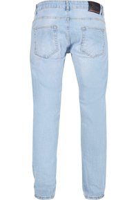 Vaqueros de denim azul claro con un diseño de pierna recta, cinco bolsillos, costuras cosidas y una etiqueta de cuero negro en la cinturilla.