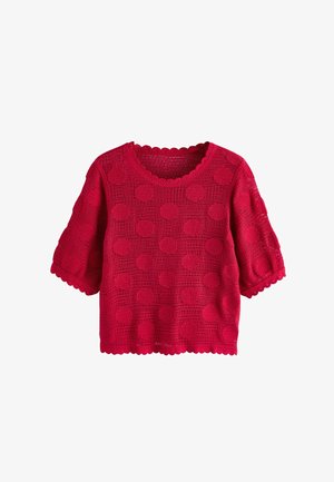 Rdeča kratka majica iz kvačkanja z okroglim izrezom, zakroženimi robovi in izrazitimi pikčastimi vzorci po celotni tkanini.