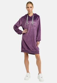 Lila Samt-Hoodiekleid mit langen Ärmeln, einer Kängurutasche und Details mit Kordelzug. Verfügt über ein dezent verarbeitetes Logo auf der Vorderseite.