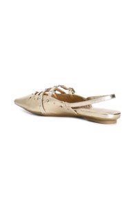 Zapatos planos dorados con punta afilada, que presentan tiras cruzadas, acentos de rhinestone y un acabado metálico suave. Diseño minimalista.