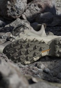 Ljusbeige utomhusskor med en texturerad gummisula, med ett mönstrat mönster och snörning. Försedda med en Continental-logga.