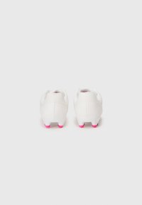 Botas de fútbol blancas con acentos en rosa en la suela. Presentan un diseño elegante y una parte superior texturizada para tracción y comodidad.