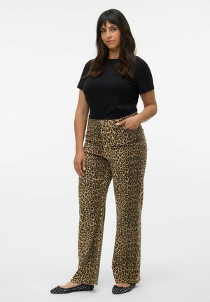 Black short-sleeve shirt paired with loose leopard print pants featuring an elastic waistband and side pockets. Black flat shoes.