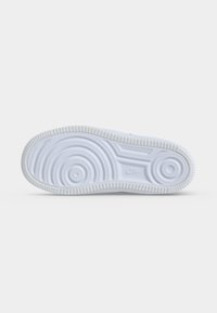 Λευκή λαστιχένια σόλα παπουτσιού Nike που δείχνει κυκλικά μοτίβα πέλματος και το λογότυπο Nike στο κέντρο σε απλό ανοιχτό φόντο.