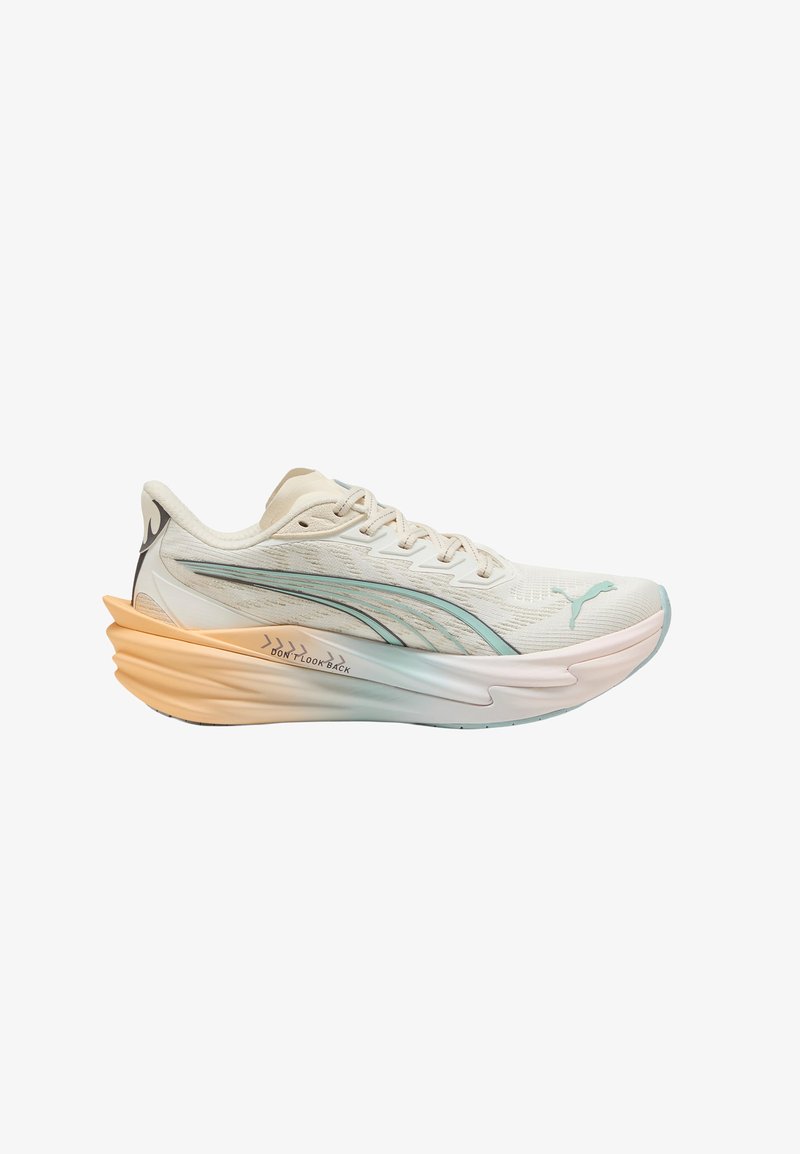 Chaussure de sport beige clair avec logo Puma bleu pâle, dessus en tissu texturé et semelle épaisse dégradée orange à blanc avec le texte « DON'T LOOK BACK ».