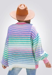 Jersey de punto sobredimensionado multicolor con rayas horizontales en rosa, azul, verde y blanco. Presenta mangas amplias y puños acanalados.