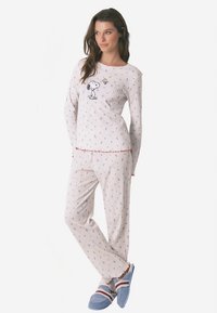 Two-piece pajama set in light cream with a ribbed texture. Features colorful prints and a Snoopy graphic on the top. Includes contrasting red trim.