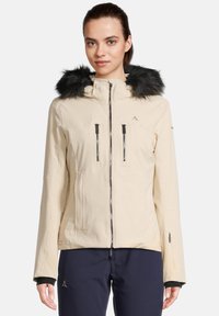 Beige wasserdichte Jacke mit einer Kapuze aus Kunstfell, zwei mit Reißverschluss versehenen Brusttaschen und einer taillierten Passform. Verfügt über schwarze Akzente und elastische Bündchen.