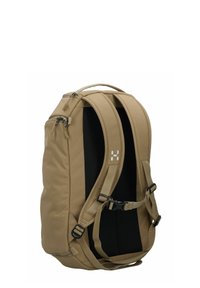 Sac à dos beige en tissu texturé, avec un dos noir rembourré, des bretelles réglables et plusieurs compartiments zippés. Présente des accents matériels minimalistes.
