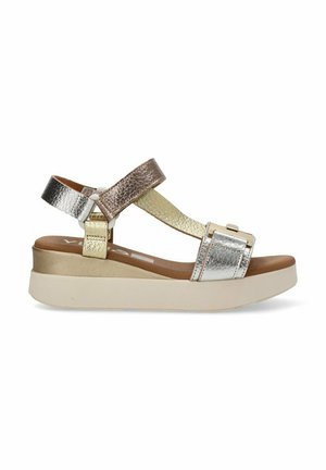 Sandalias metálicas en plata y oro con suela de plataforma, que presentan tiras entrecruzadas y un acabado texturizado. Cierre ajustable con hebilla.