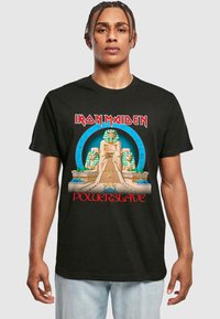 Svart bomull t-skjorte med et egyptisk inspirert grafikk, som viser en stor statue, pyramider og teksten "Iron Maiden Powerslave" i rødt.
