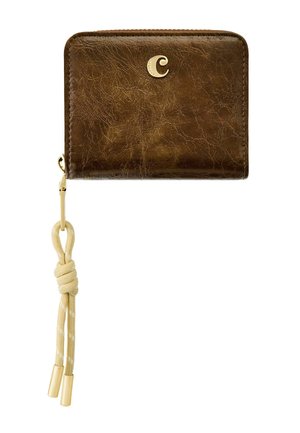 Braunes, strukturiertes Lederportemonnaie mit goldenem "C"-Emblem und beigefarbenem, verknotetem Band, das an einem goldenen Reißverschlussanhänger befestigt ist.