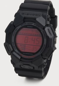 Montre numérique Casio G-Shock noire avec affichage LED rouge, bracelet en caoutchouc, boîtier texturé et plusieurs boutons de fonction ; étanche jusqu'�à 20 bars.