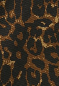 Tkanina s leopardím vzorom s čiernym pozadím a hnedými a pieskovými škvrnami, ktorá zobrazuje textúrovaný, ribbovaný povrch.