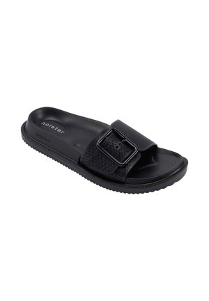 Black slide sandal with textured footbed, perforated strap, and large adjustable buckle, branded "holster" on sole and side.