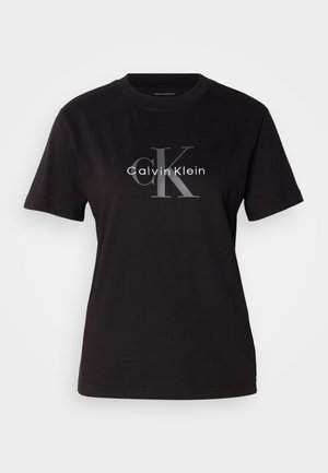 Zwarte katoenen T-shirt met korte mouwen, een ronde halslijn en een centraal logoontwerp met "Calvin Klein" en "CK" in het grijs.